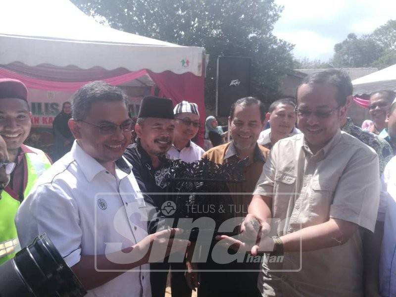 Ahmad Samsuri (kanan) melepaskan burung puyuh dari jebak se ... ian jalan baharu Kampung Jebak Puyoh, di sini, semalam