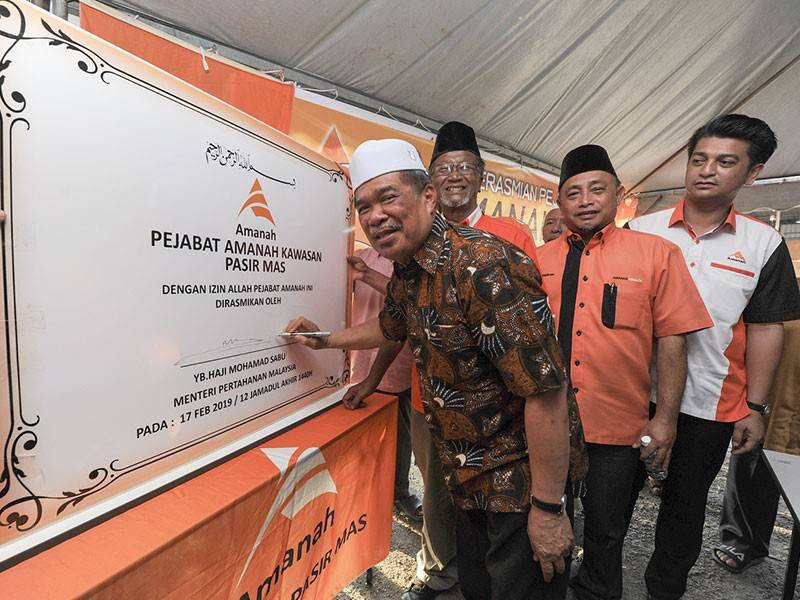 Presiden Parti Amanah Negara (Amanah), Mohamad Sabu menandatangani plak sebagai simbolik perasmian Pejabat Amanah Pasir Mas di Kampung Jias, hari ini. - Foto Bernama