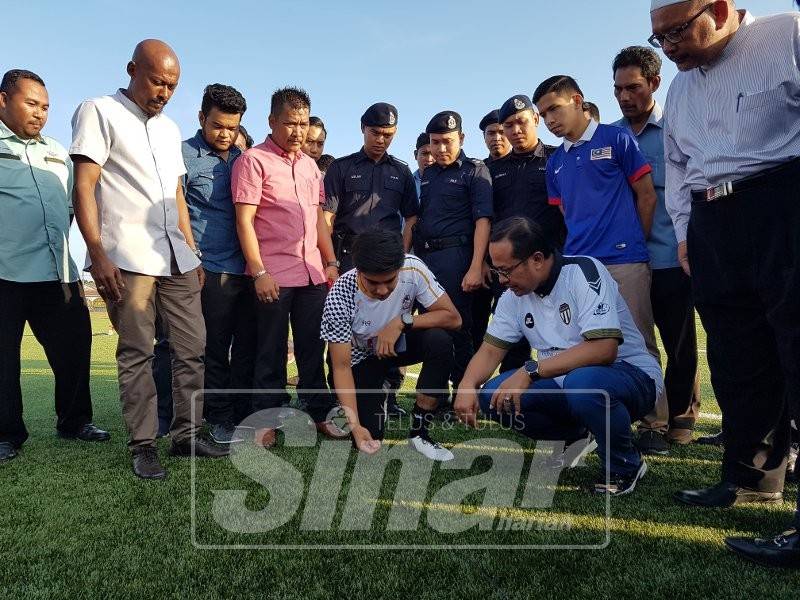 Syed Saddiq (duduk, kiri) dan Ahmad Samsuri melihat dari dekat keadaan Padang Sintetik Stadium Mak Chili pada majlis penyerahan padang itu oleh KBS kepada MPK lewat petang semalam.