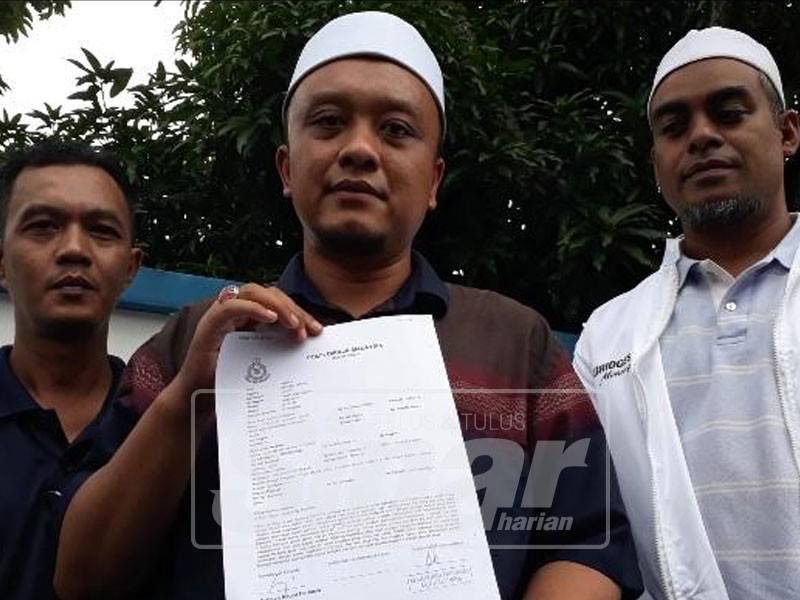 Ahmad Akmal M Tahrir menunjukkan salinan laporan polis yang dibuat.