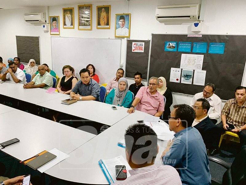 Mohd Sofi (duduk, dua, kiri) mengadakan perbincangan dengan pekerja kaunter tiket, wakil pengendali syarikat bas dan pengurusan Melaka Sentral Sdn Bhd di terminal bas terbabit.