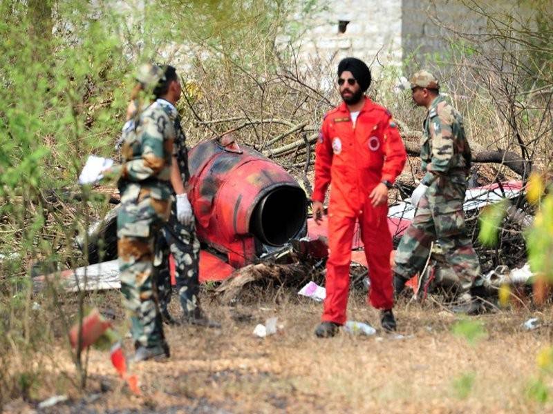 Tentera berdiri berhampiran bangkai selepas dua pesawat Hawk dari Pasukan Paparan Aerobatic Surya Kiran Tentera Udara India bertembung di udara tengah sambil berlatih mendahului Aero India di Tentera Udara Yelahanka di Bengaluru, India. - Reuters
