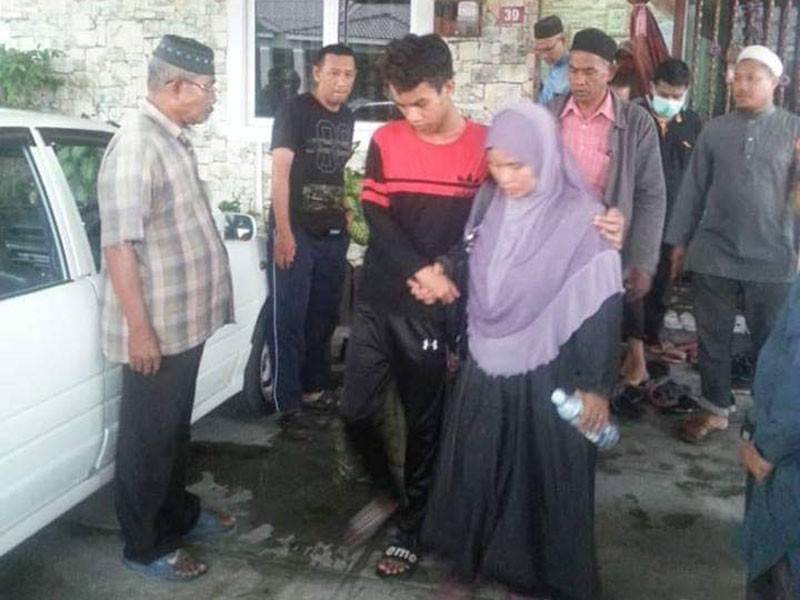  Muhammad Ariff (tengah) ditemani ibunya sewaktu hendak dibawa ke Hospital Parit Buntar bagi mendapatkan rawatan lanjut dengan menaiki ambulans. FOTO: Kredit pembaca