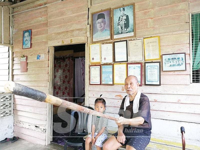 Harun bersama cicitnya menunjukkan sumpit berusia lebih 50 tahun yang digunakan untuk memburu.