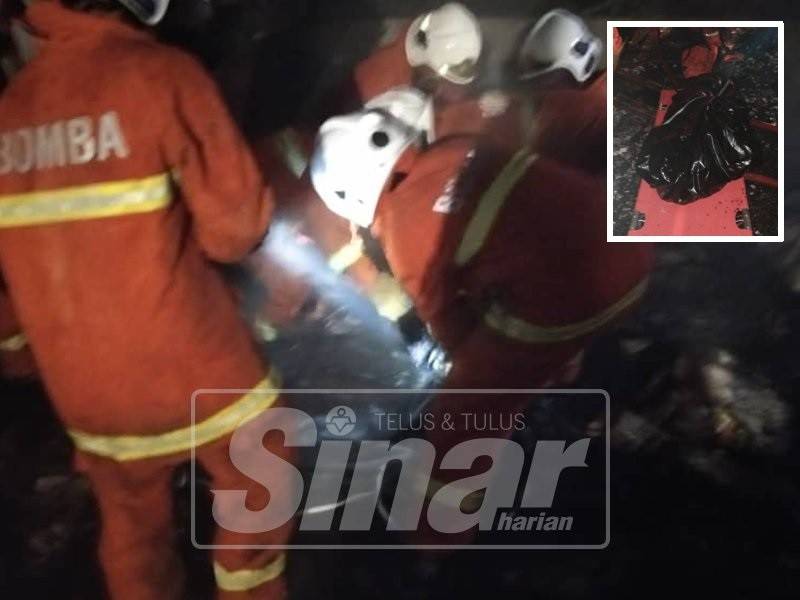 Anggota bomba mengeluarkan mayat mangsa.