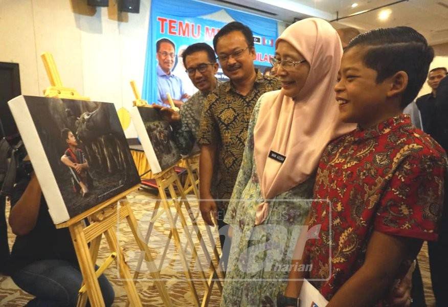  Wan Azizah dan Muhammad Syukur (kanan) melihat hasil karya Abdullah Dean.