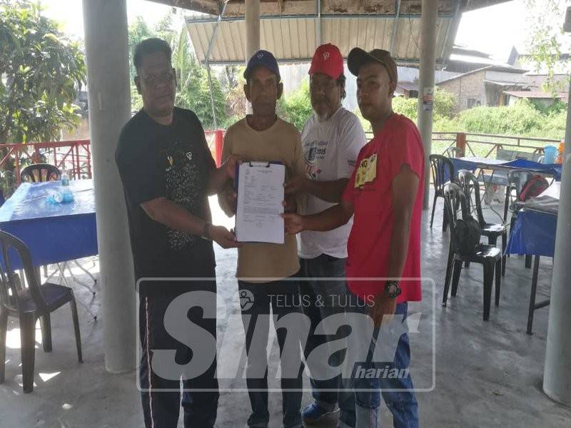 Shukor (dua, kiri) bersama sebahagian wakil nelayan komuniti Kampung Dew menunjukkan laporan polis dibuat ke atas aktiviti menebang pokok berembang atas tujuan khianat pada Ahad lalu.