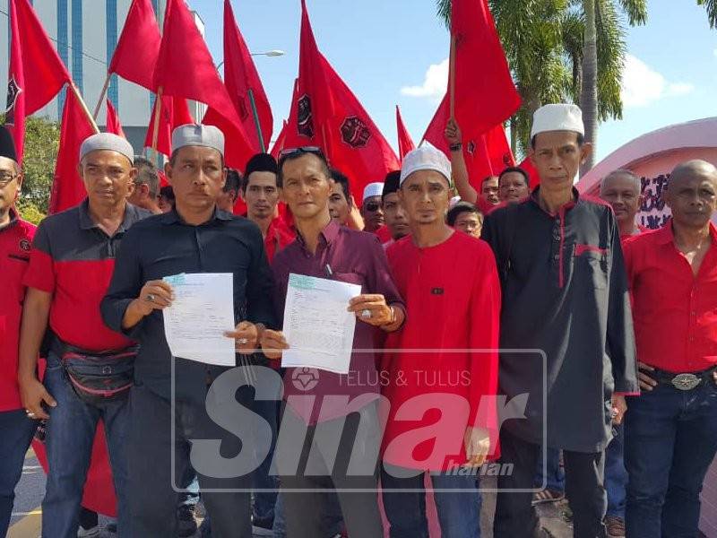 Ahmad Sukri (tengah) menunjukkan salinan laporan polis selepas membuat laporan terhadap individu menghina Islam dan Nabi Muhammad SAW.