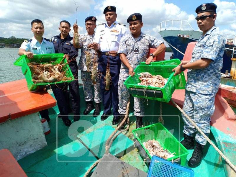 Pannir (tengah) bersama pegawai dan anggota TLDM memeriksa hasil laut hidup yang dirampas dari bot Vietnam yang ditahan.