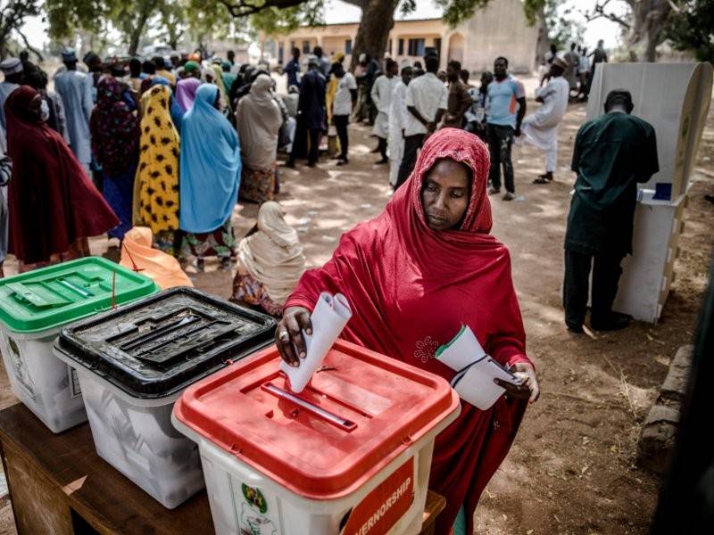 Seorang wanita membuang undi di pusat pengundian di kem pelarian Malkohi di Jimeta, Adamawa.