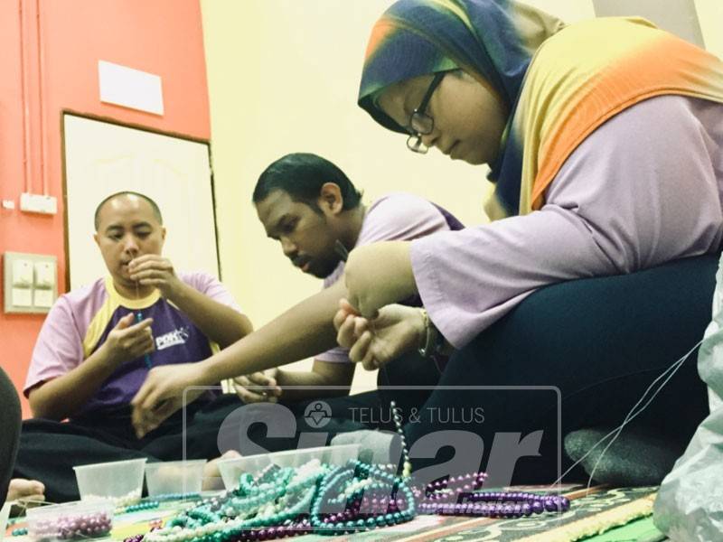 Pelatih PDK dipantau penyelia membuat tasbih sebagai terapi untuk mereka berdikari.