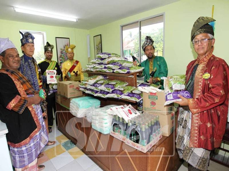 Khalid (kanan) menunjukkan sebahagian barangan keperluan dapur yang disediakan untuk golongan yang benar-benar terputus bekalan makanan di rumah.
