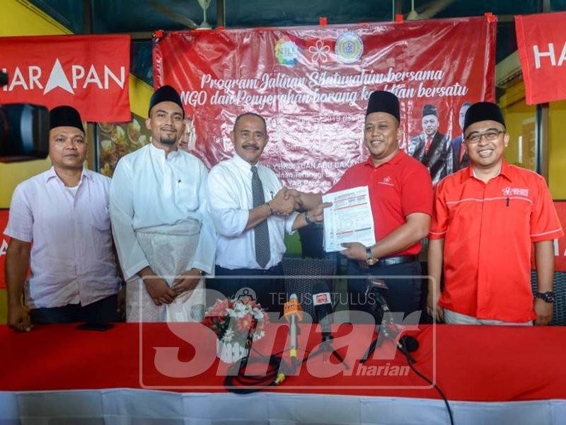 Abu Bakar (tiga, kiri) menyerahkan borang keahlian Bersatu kepada Presiden Persatuan Usahawan Warisan Malaysia, Mohammed Yasri Mohd Bedu (dua, kanan) pada Program Jalinan Silaturahim Bersama NGO dan Penyerahan Borang Keahlian Bersatu di Taman Pelangi, Semenyih. - Foto SHARIFUDIN ABDUL RAHIM