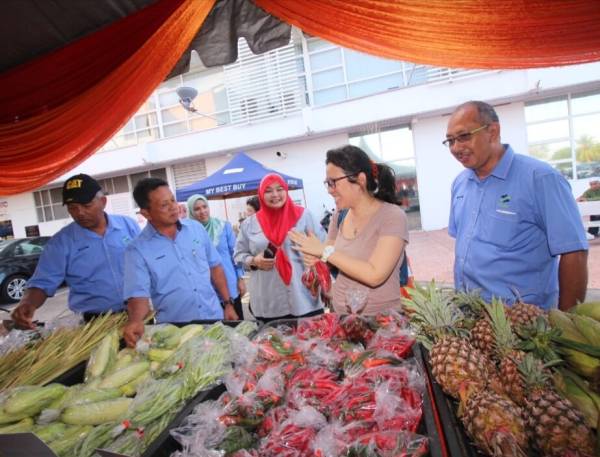 Samudin (dua,kiri) bertanyakan sesuatu kepada pelanggan ketika
program My Best Buy dan jualan terus dari ladang peringkat negeri di bangunan UTC, di sini, hari ini.