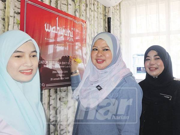 Rina menurunkan tandatangan di atas plak ketika melawat Wahyuni Spa dan Muslimah Beauty.