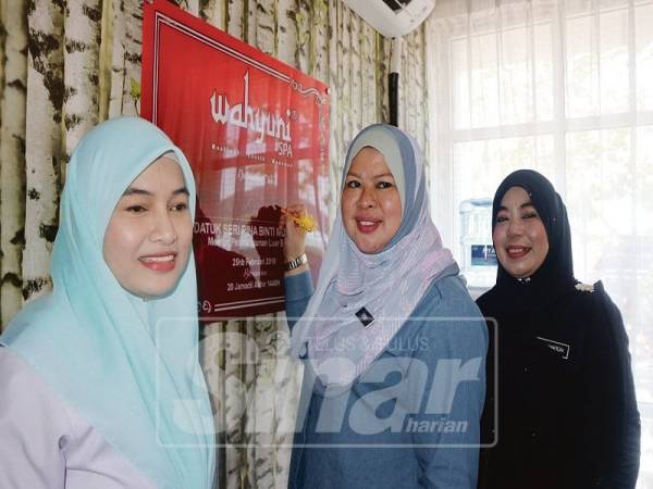 Rina menurunkan tandatangan di atas plak ketika melawat Wahyuni Spa dan Muslimah Beauty.