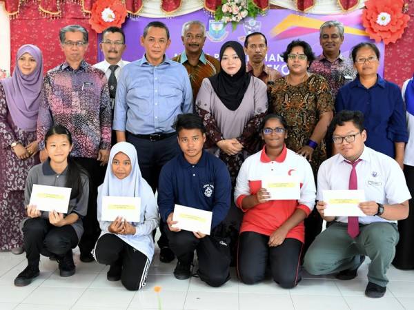 Menteri Besar, Datuk Seri Aminuddin Harun (tiga berdiri, kiri) bergambar bersama tetamu, ibu bapa dan pelajar pada Mesyuarat Persatuan Ibu Bapa dan Guru (PIBG) dan Penyampaian Bantuan Awal Persekolahan di Sekolah Menengah Kebangsaan (SMK) Warisan Putri, Sikamat, hari ini. - Foto Bernama
