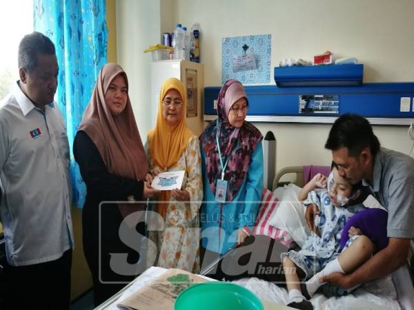 Izrinda (dua Kiri) menerima sumbangan disampaikan Noraini (tengah) dan Zariny.