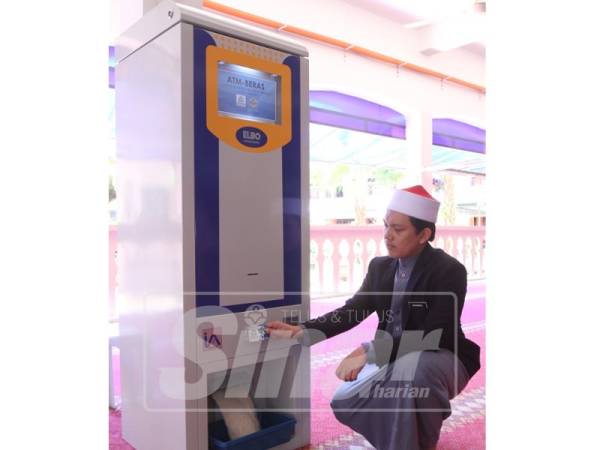 Muhammad Khairul Razikin menunjukkan cara mesin ATM beras beroperasi.