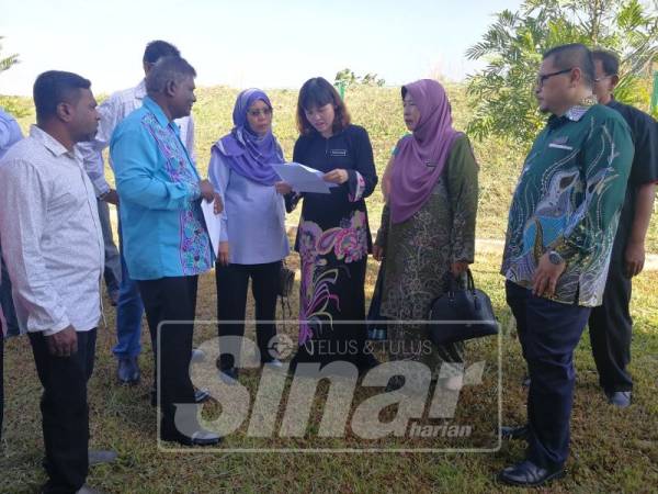 Nie Ching (tengah) melihat aduan tambahan yang disampaikan Francis (dua, kiri) ketika kunjungan ke SJKT Ladang Coalfields.