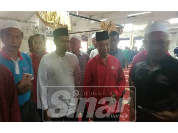 Muhammad Aiman ditemani Presiden Bersatu Tan Sri Muhyiddin Yassin selepas usai solat Jumaat di Masjid Raja Muda Musa, Pekan Semenyih hari ini.