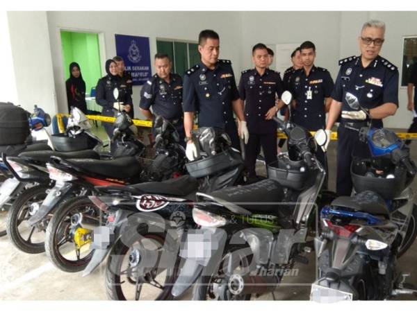 Rasikin (kanan) menunjukkan motosikal yang dirampas daripada Geng Imut baru-baru ini.