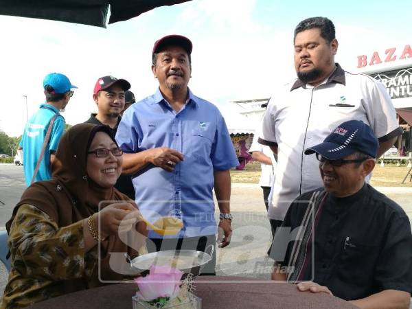 Fuziah mencuba cendol durian yang dijual peniaga gerai Program My Best Buy dan Jualan Terus Dari Ladang di Serambi Teruntum, semalam.