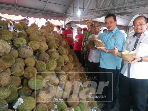 Azman (tengah) menunjukkan durian disediakan dalam Pesta Durian 2019.