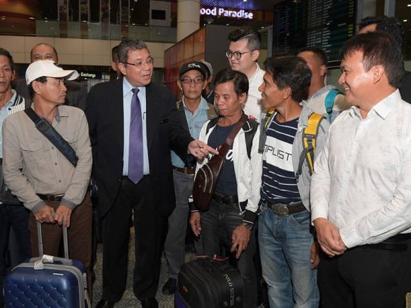 Menteri Luar Datuk Saifuddin Abdullah (tiga, kiri) beramah mesra bersama lapan rakyat Malaysia yang terkandas di Monrovia, Liberia ketika menyambut ketibaan mereka di Lapangan Terbang Antarabangsa Kuala Lumpur (KLIA) hari ini. - Foto Bernama