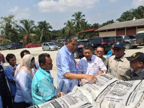 Salahuddin (tiga kanan) melihat baja NPK yang akan diserahkan kepada pesawah.