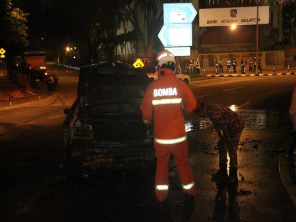 Anggota bomba sedang memeriksa kenderaan yang terlibat dalam kebakaran tersebut.
