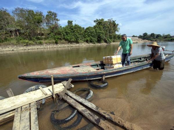 Seorang pembawa bot tambang, Din Mamat, 50, (kanan) menceritakan dia perlu berhati-hati kerana bimbang terlanggar bongkah kayu atau batu yang ada di dasar Sungai Golok. - Foto Bernama