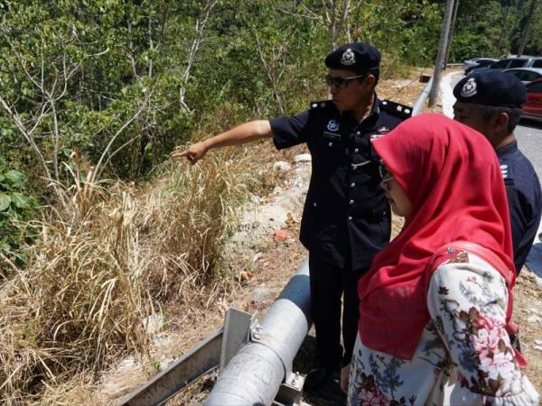 Ketua Polis Daerah Langkawi Supt Mohd Iqbal Ibrahim (kiri) menunjukkan gaung di Gunung Raya lokasi mayat kanak-kanak perempuan berusia tiga tahun ditemukan pagi tadi. - Foto Bernama