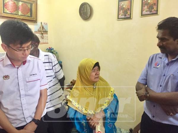 Mardiah (tengah) tidak dapat menahan sebak menceritakan mengenai arwah anaknya kepada Anthony (kanan) ketika menerima kunjungan Perkeso, baru-baru ini.