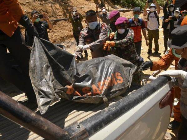 Pasukan penyelamat mengangkat beg mayat mangsa runtuhan lombong emas haram di Bolaang Mongondow di Sulawesi Utara.