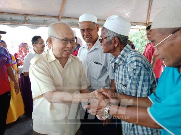 Tengku Razaleigh bersalaman ketika hadir pada program berkenaan.