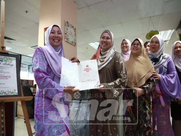 Hamizun (dua, kiri) mewakili Jabatan Korporat dan Pengurusan Strategik MPSJ menyerahkan kad ucapan sempena Hari Wanita 2019 kepada Noraini (kiri).
