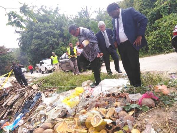 Veerapan (kanan) melawat lokasi pembuangan bahan buangan klinikal yang ditemui di Kampung Felda Sendayan.