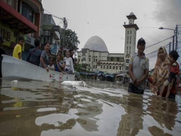  Penduduk meredah banjir di sebatang jalan di Dayeuhkolot, Bandung.