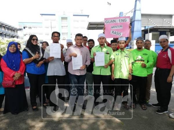 Mohd Norhiesam (lima, kiri) bersama Ellangovan (empat, kiri) dan Abdul Mushawwir (empat, kanan) menunjukkan laporan polis yang dibuat mereka terhadap Menteri Kewangan, Lim Guan Eng.