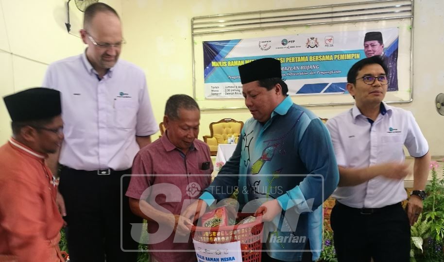  Mazlan menyampaikan barangan makanan kepada peneroka generasi pertama Felda Ulu Tebrau di sini, hari ini.