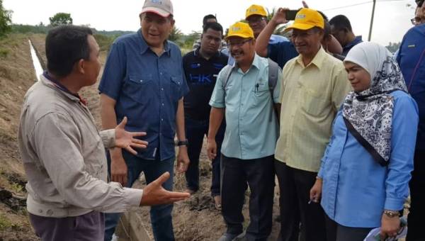 Wakil petani menjelaskan masalah dihadapi pesawah kepada Sallehuddin (tengah) di Kampung Seri Penaga, semalam.