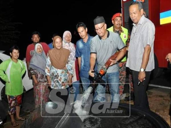 Wakil persatuan dan penduduk mengisi penuh sebuah tangki air.