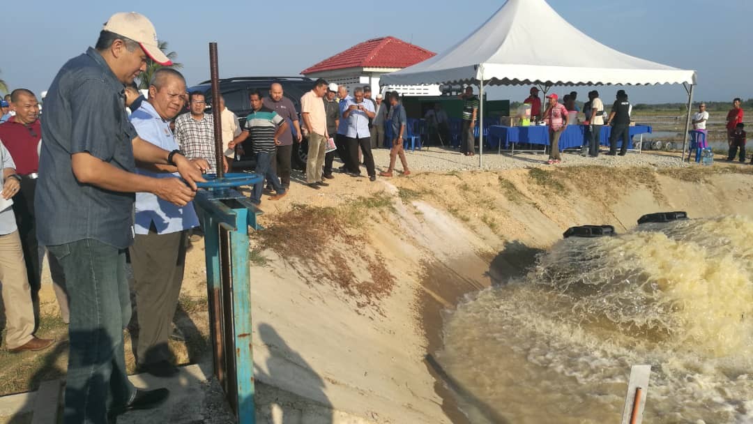 Mohd Sallehuddin (kiri) membuka pintu kawalan air di Stesen Pam Tali Air Bedang Nara.