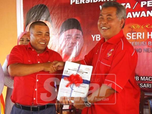 Ahmad (kanan) menerima borang ahli UMNO yang baharu dari Pengerusi UMNO Bahagian Dungun, Datuk Din Adam.