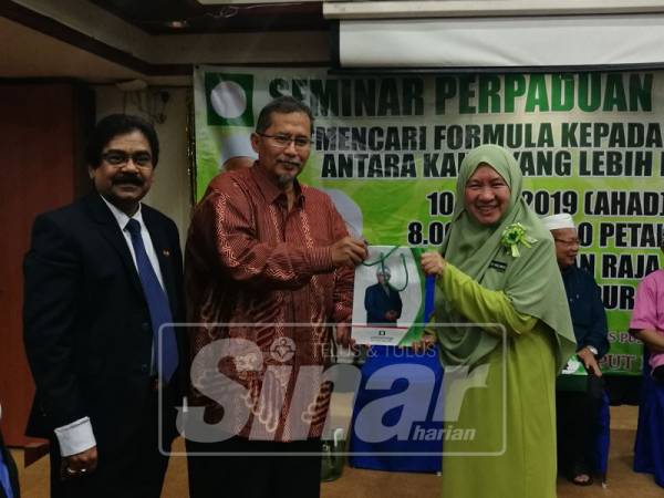 Iskandar (tiga dari kanan) menyampaikan cenderamata kepada pembentang seminar itu