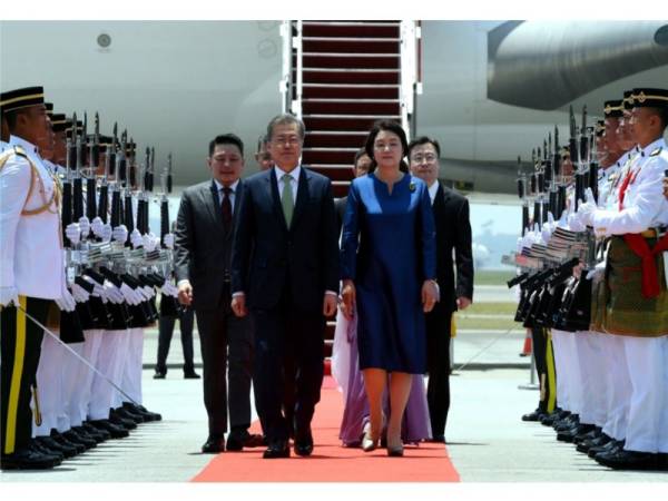 Moon Jae-in dan isteri Kim Jung-sook melintasi kawalan kehormat sejurus tiba di Kompleks Bunga Raya hari ini sempena lawatan negara tiga hari sehingga Khamis. - Foto Bernama