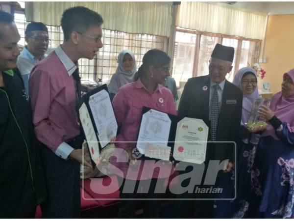 Dhivya (dua kiri) dan Chin Seng diraikan selepas sidang media khas di sekolah hari ini.