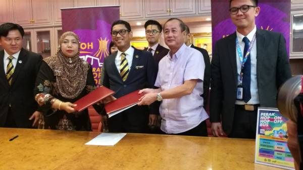 Ahmad Faizal (tengah) ketika menyaksikan perjanjian bagi perkhidmatan Hop On Op Off (Hoho) antara Tourism Perak.
