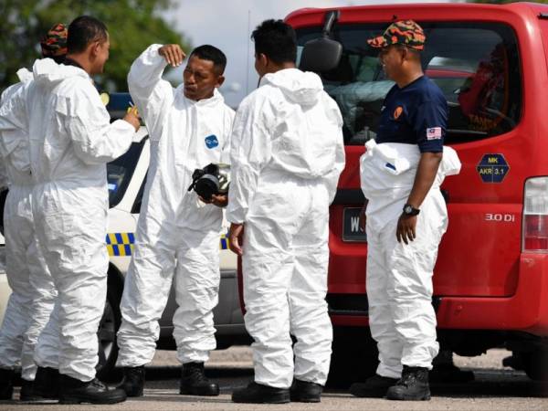 Pasukan Unit Hazmat (Bahan Berbahaya) Jabatan Bomba dan Penyelamat bersiap sedia memakai pakaian khas dipercayai bagi melakukan pemeriksaan di kawasan insiden pencemaran bahan kimia di Pusat Kawalan Lapangan (Ground Command Centre) Dewan Komuniti Taman Pasir Putih Pasir Gudang hari ini. - Foto Bernama